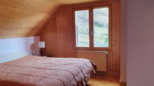a bedroom with a bed and a window at Chalet Le Chant des Etoiles in Mende