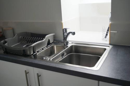 a kitchen sink with a dish drying rack next to it at Self-contained 1-Bed Apartment in Kirriemuir in Kirriemuir