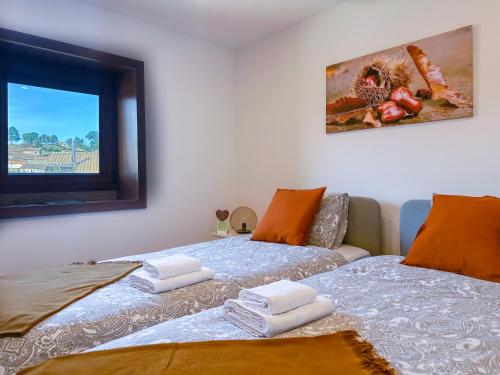 dos camas sentadas una al lado de la otra en un dormitorio en Casa do Souto - Nature & Experiences - Turismo Rural, en Bragança
