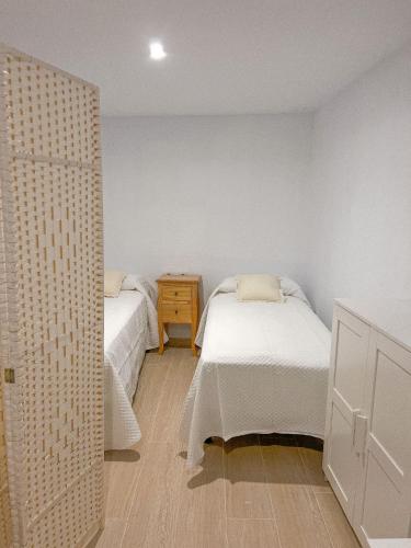 a bedroom with two twin beds and a dresser at El rincon de Marisa in Vejer de la Frontera