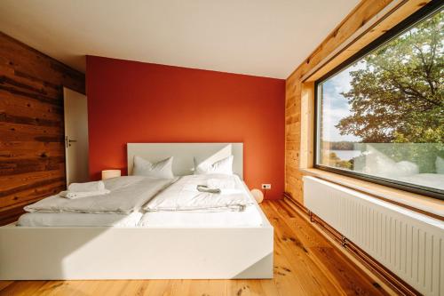- une chambre avec un lit blanc et une grande fenêtre dans l'établissement Ferienhaus Haus Übersee, à Schwarz