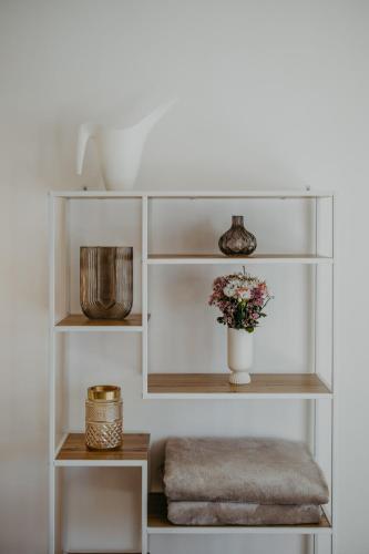 a white shelf with a vase of flowers on it at Villa SEEhnsucht in Jois