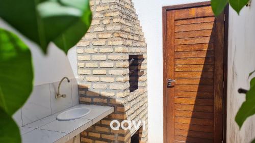 uma casa de banho com um lavatório de pedra ao lado de uma porta em Qavi - Casa Tropical #ParaísoDoBrasil em Touros