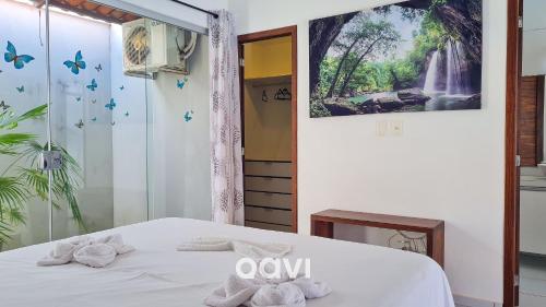 a bedroom with a bed with towels on it at Casa Tropical Com Piscina por Quarto à Vista in Lagoa do Mato