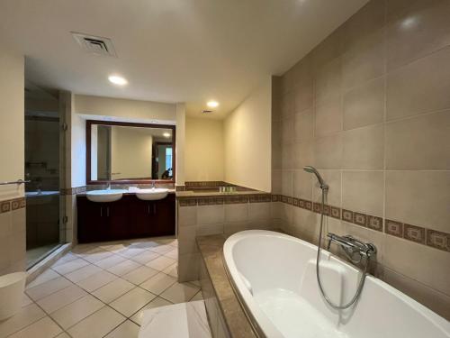 baño grande con bañera y lavamanos en 2Bedroom Palm Jumeirah luxury Stay At Golden Mile 10, en Dubái
