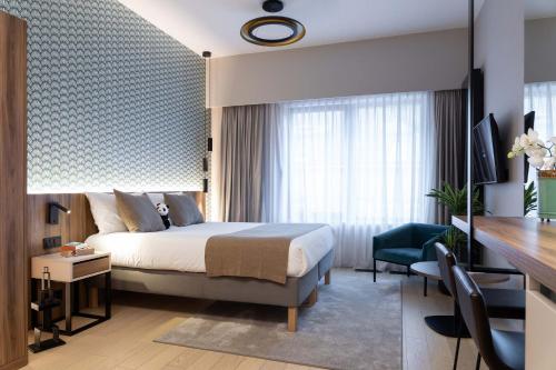 um quarto de hotel com uma cama e uma secretária em The Central Kirchberg - Smart ApartHotel em Luxemburgo