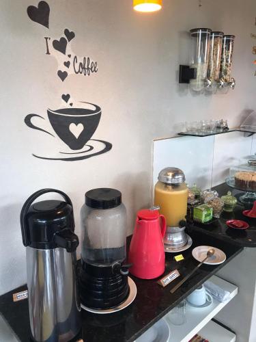 a counter with a coffee maker and a sign on a wall at AYRE GOSTOSO POUSADA in São Miguel do Gostoso