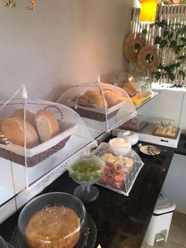 a counter with several trays of bread and other foods at AYRE GOSTOSO POUSADA in São Miguel do Gostoso