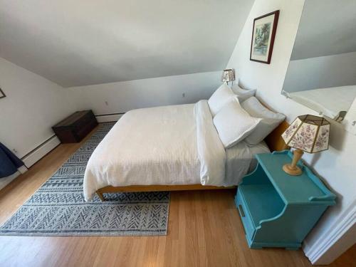 um quarto com uma cama e uma mesa de cabeceira com um candeeiro em Centrally Located Winooski Apartment em Winooski