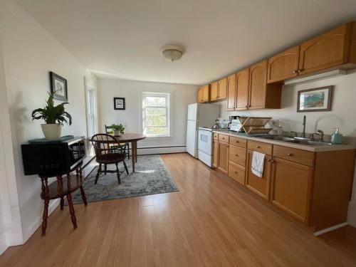 uma cozinha com pisos em madeira, uma mesa e cadeiras em Centrally Located Winooski Apartment em Winooski