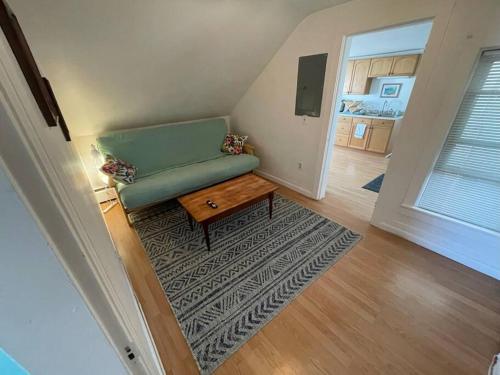 a living room with a green couch and a table at Centrally Located Winooski Apartment in Winooski