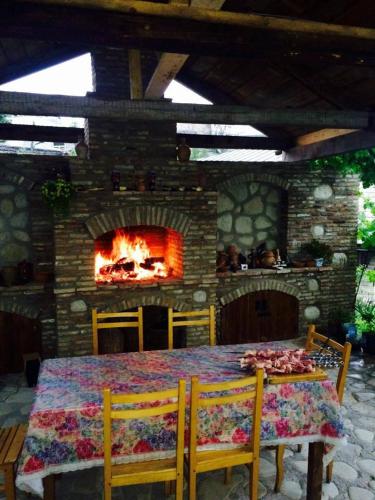 a dining room with a table and a fireplace at Guest House Kusika in Sighnaghi