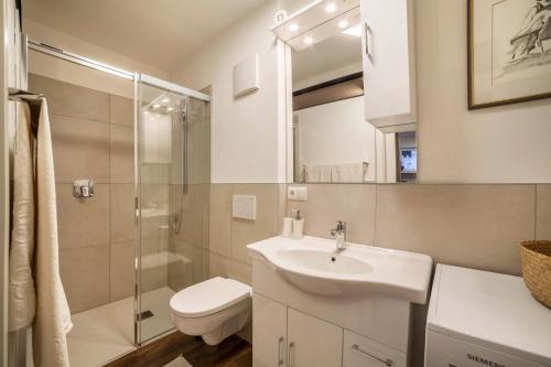 a bathroom with a sink and a toilet and a shower at Holzer's Apartment in San Leonardo in Passiria