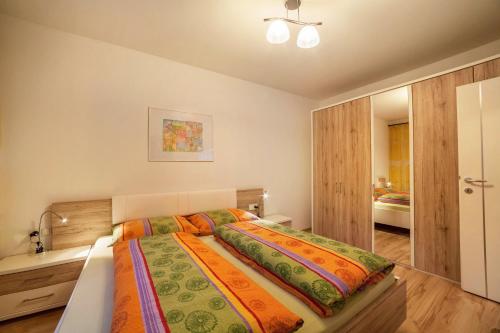 1 dormitorio con 1 cama grande con sábanas coloridas en Holzer's Apartment en San Leonardo in Passiria