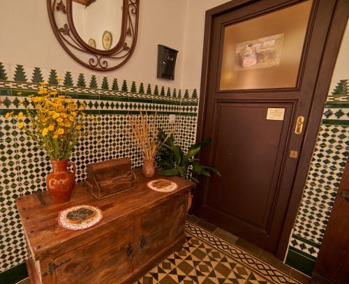 Con una mesa de madera con flores y un espejo en Tragaluz II, en Fuenteheridos