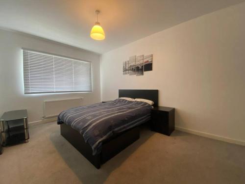 een slaapkamer met een groot bed en een raam bij Stunning 2 Bedroom Apartment in Croydon