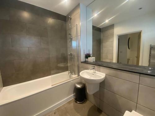 a bathroom with a sink and a toilet and a tub at Stunning 2 Bedroom Apartment in Croydon