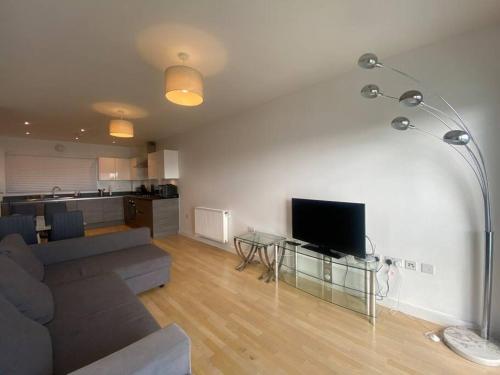 a living room with a couch and a flat screen tv at Stunning 2 Bedroom Apartment in Croydon