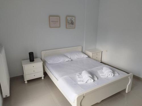 Un dormitorio con una cama blanca con toallas. en Ευρύχωρη και φωτεινή κατοικία στη Ζάκυνθο en Makhairádhon