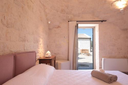 um quarto com uma cama e uma porta para um pátio em Trulli & Dimore - Trulli Lorusso em Castellana Grotte