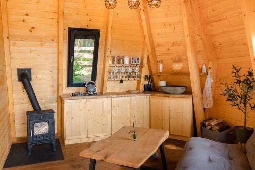 ein Zimmer mit einem Herd und einem Tisch in einer Hütte in der Unterkunft Diamond Cabin Orava in Párnica