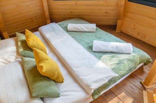 a large bed in a room with pillows on it at Diamond Cabin Orava in Párnica