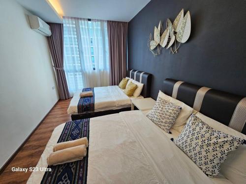 een hotelkamer met 2 bedden en een bank bij Lovely Vivacity Jazz 2 Cozy Condo 2 Card LV6B in Kuching