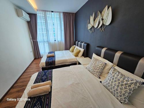 a hotel room with two beds and a couch at Lovely Vivacity Jazz 2 Cozy Condo 2 Card LV6B in Kuching