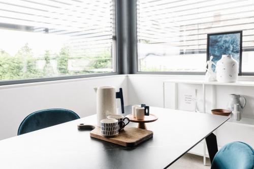 une table blanche dans une pièce avec des chaises bleues dans l'établissement Exklusive Design Appartement Deep Blue Neubau, à Pfungstadt