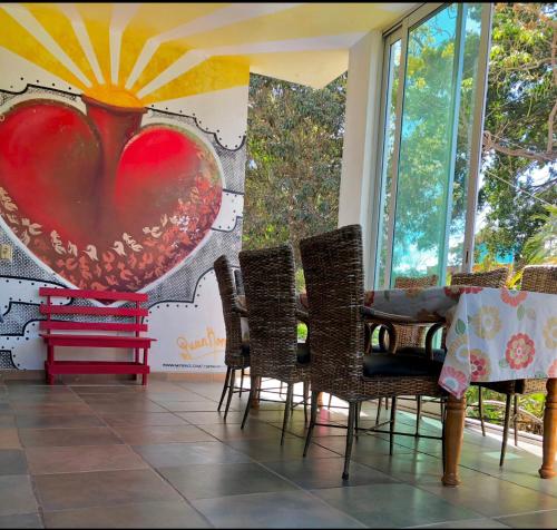 um quarto com cadeiras e uma pintura de um coração em Surf N Roll House em Sayulita
