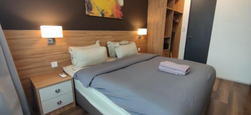 1 dormitorio con 1 cama y mesita de noche con 2 lámparas en H&W Sunway Onsen Suite Tambun Sunway City Ipoh, en Ipoh