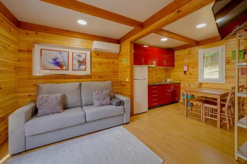 a living room with a couch and a kitchen at Arrabia Guest Houses Glamping in Raiva