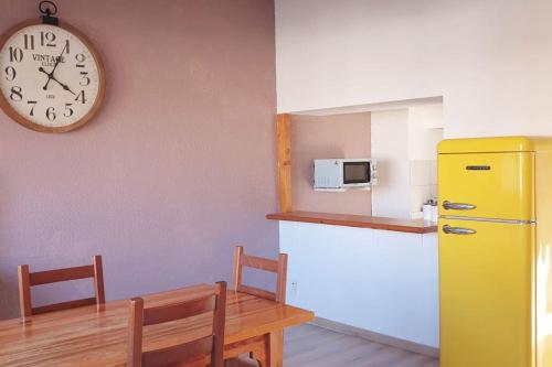 une cuisine avec une table et une horloge au mur dans l'établissement hyper-centre plage à 100 mètres, à Valras-Plage