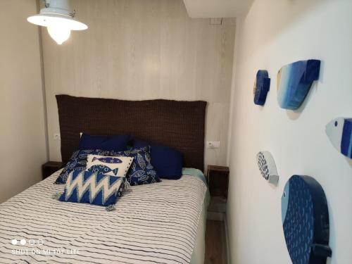 - une chambre avec un lit doté d'oreillers bleus et blancs dans l'établissement Apartamento a pie de playa en Bakio, à Bakio