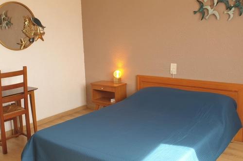 - une chambre avec un lit bleu et une bougie sur une table dans l'établissement hyper-centre plage à 100 mètres, à Valras-Plage
