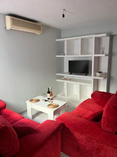 sala de estar con sofá rojo y mesa en Apartamento HM Renfe, en Córdoba