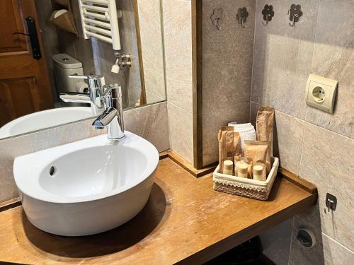 La salle de bains est pourvue d'un lavabo blanc et d'un miroir. dans l'établissement Casa Bernat Apartament, à Puigcerdà