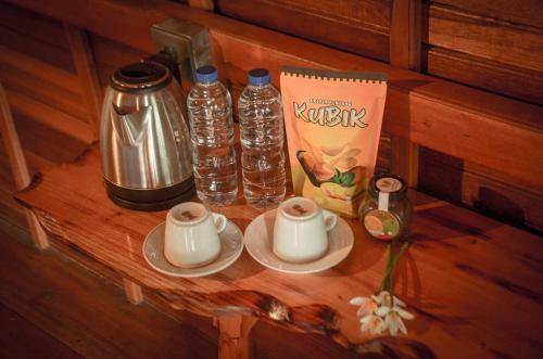 a table with two bottles of water and a book at The Hills Kerinci in Kayu Aro