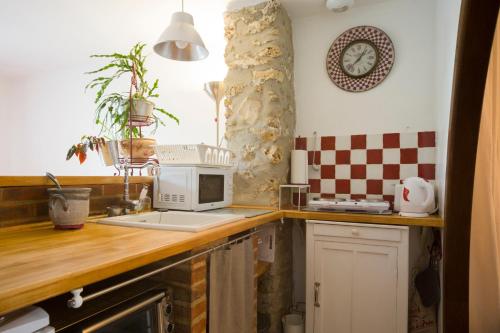 a kitchen with a counter top with a microwave on it at Le charmant in Bussy-Saint-Georges