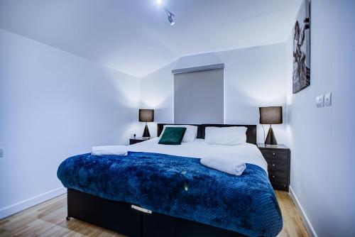 a bedroom with a large bed with a blue blanket at Peckham Plaza in London