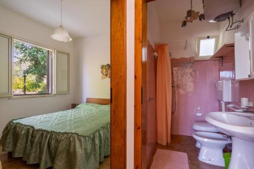 y baño con cama, lavabo y aseo. en Villa Fioralba, en Castrignano del Capo