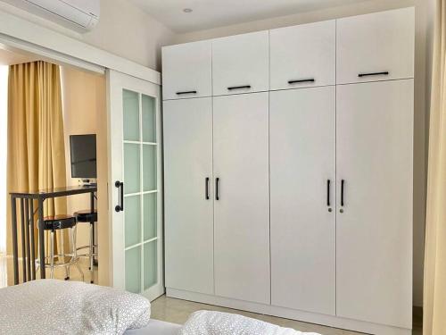 a bedroom with white cabinets and a bed at Rose 6 Comfort living at Cleopatra in Alanya