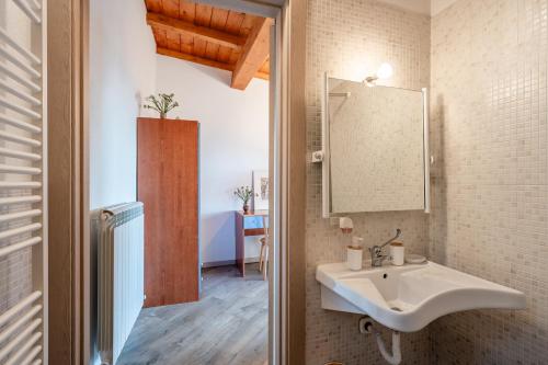 La salle de bains est pourvue d'un lavabo et d'un miroir. dans l'établissement Agriturismo La Vecchia Scuola, à Villa Collemandina