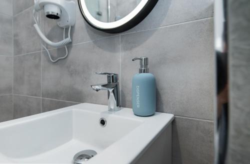 a bathroom with a blue soap bottle on a sink at Apartament Dworcowa 24 in Gliwice