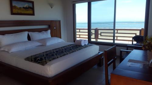 a bedroom with a bed with a view of the ocean at La Bocana de Quiximies Hotel in Cojimíes