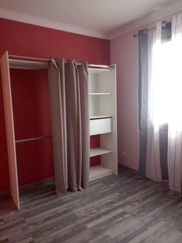 a room with red walls and a closet with curtains at HAUT VILLA MESANGES EN BORD DE MER ! in Lucciana