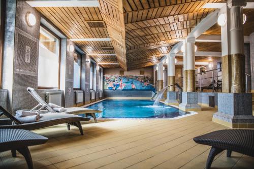 a swimming pool in a building with a gym at Krupówki 40 in Zakopane