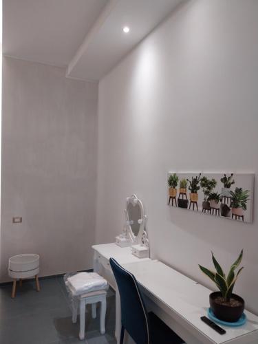 Camera bianca con scrivania e sedie. di Suite al Borgo ad Aversa