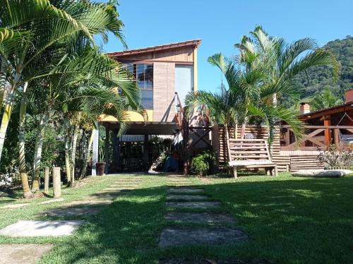 uma casa com palmeiras em frente em sítio recanto verde do sol em Guarapari