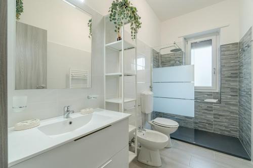 La salle de bains blanche est pourvue d'un lavabo et de toilettes. dans l'établissement Welcome to Turin! Apartment Regina Margherita, à Turin